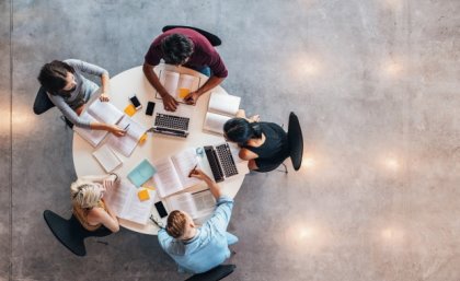 Bringing social work and law students together led to increased awareness of each other's perspective. Image: Adobe an aerial view of five people sitting at a table with laptops and open books
